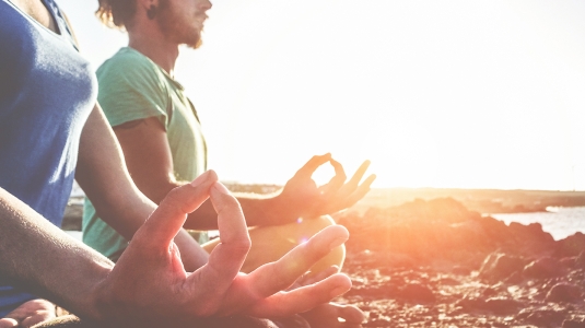 2 people doing yoga at sunset