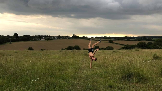 Archie doing a handstand in a field