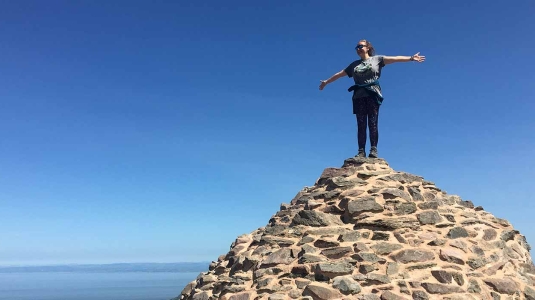 Girl standing in top of pile of rocks