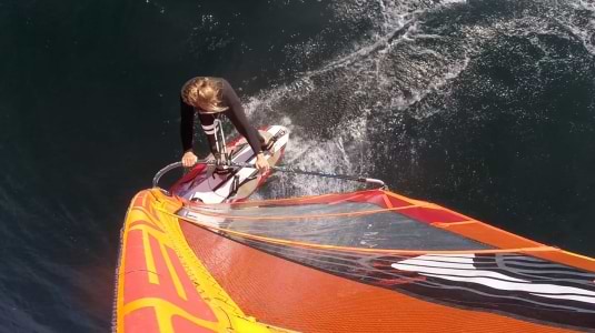 Girl windsurfing in a wetsuit
