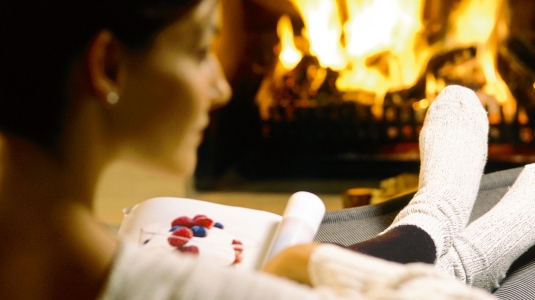 lady with feet up in front of a fire