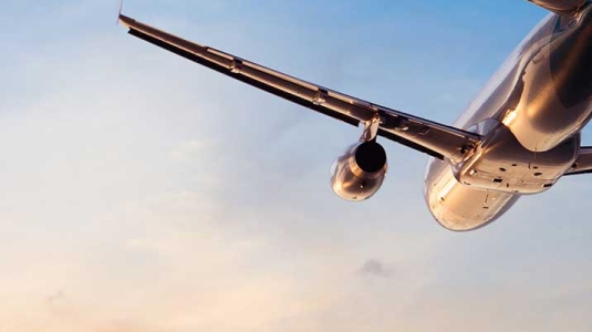 plane flying into the sunset