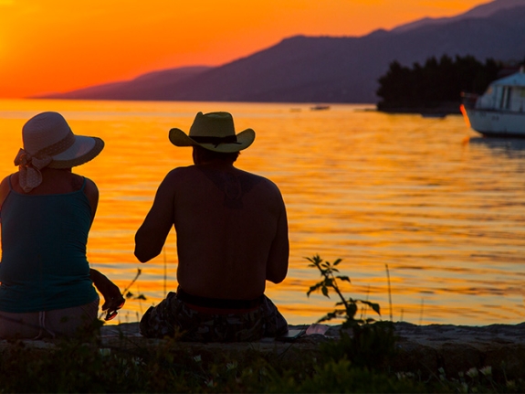 A couple watching the sunset from Alana Beachclub
