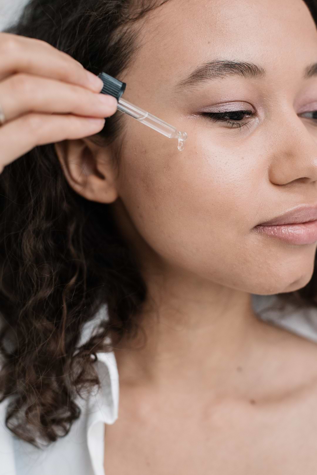 Femme qui applique un cosmétique sur sa peau