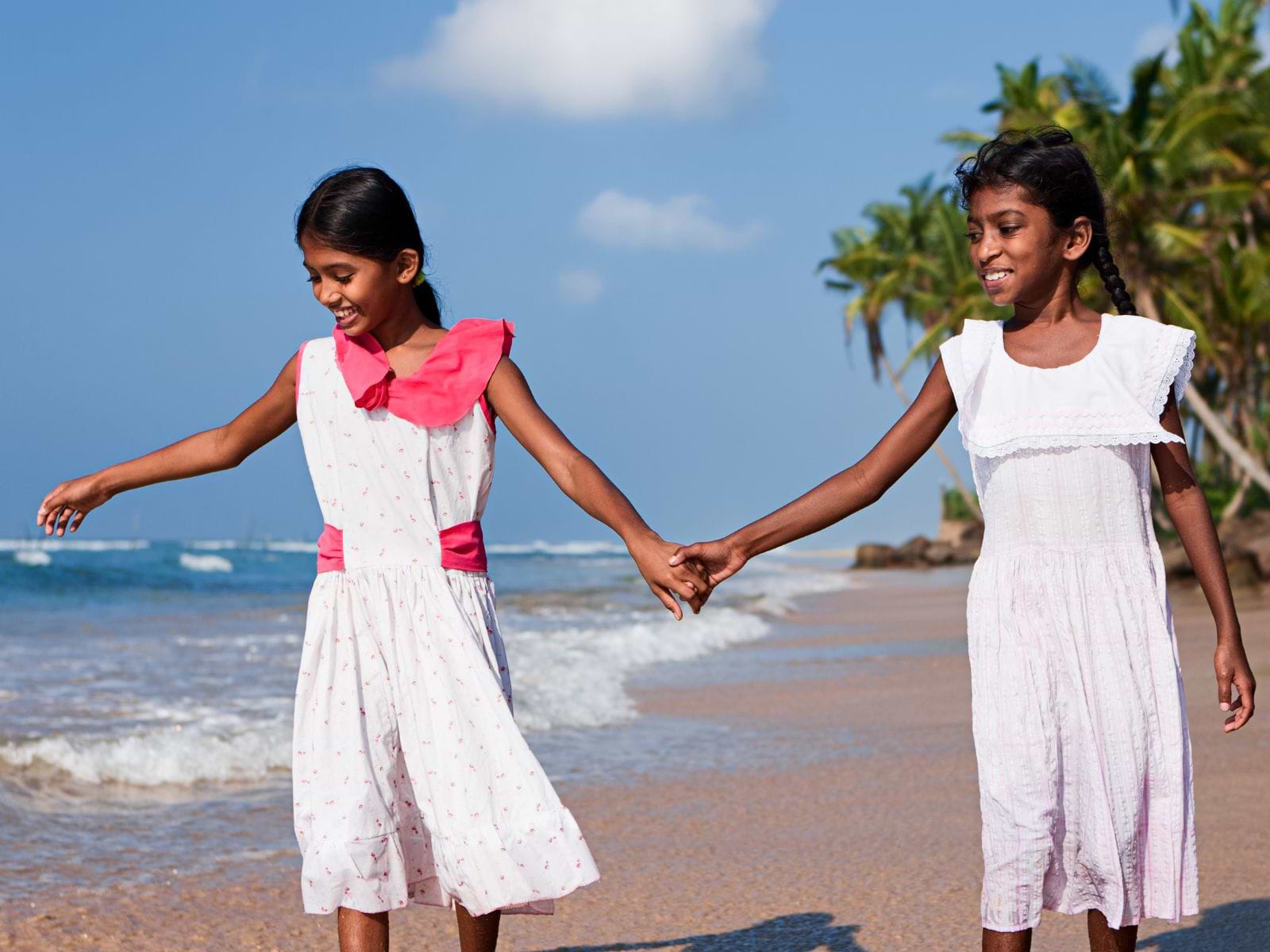 To smilende tamilske piger på strand i Sri Lanka