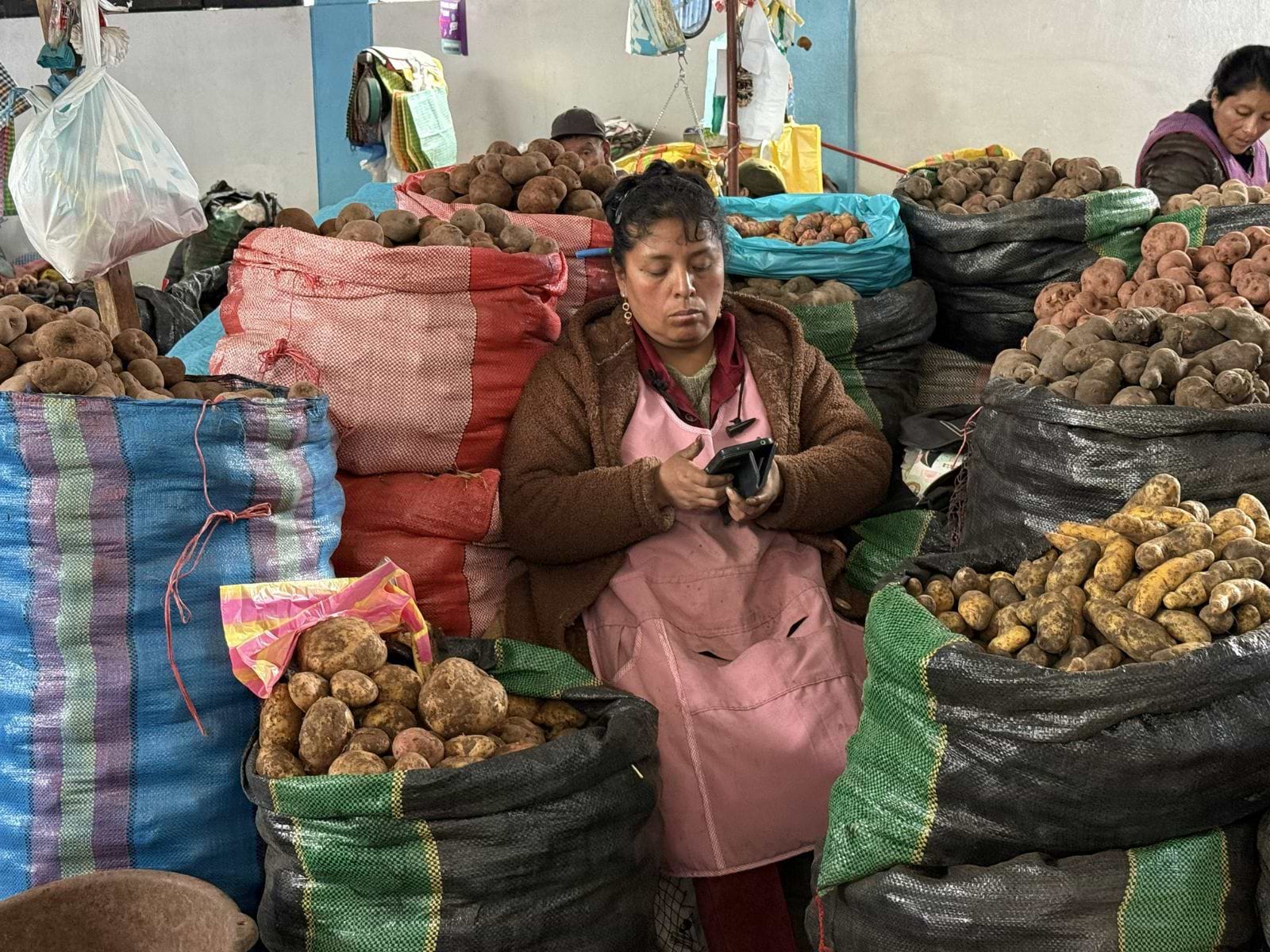 Kvinde sælger kartofler på marked i Peru