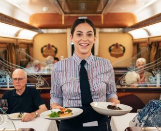 Glad tjener i restaurantvognen ombord på Indian Pacific-toget i Australien