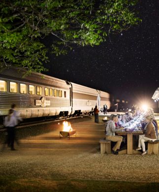 Passagerer på The Ghan spiser middag på perronen under den australske nattehimmel