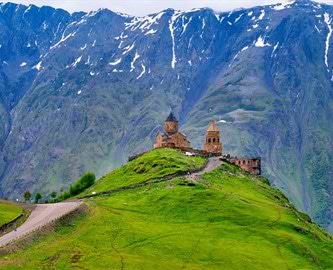 Treenighedskirken Gergeti ligger idyllisk og imponerende placeret i Kazbegi, Georgien