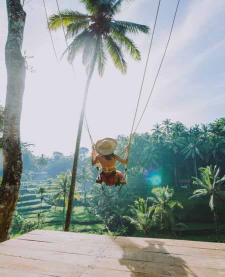 Kvinde gynger over junglen ved Tegalalang risterrasserne i Bali