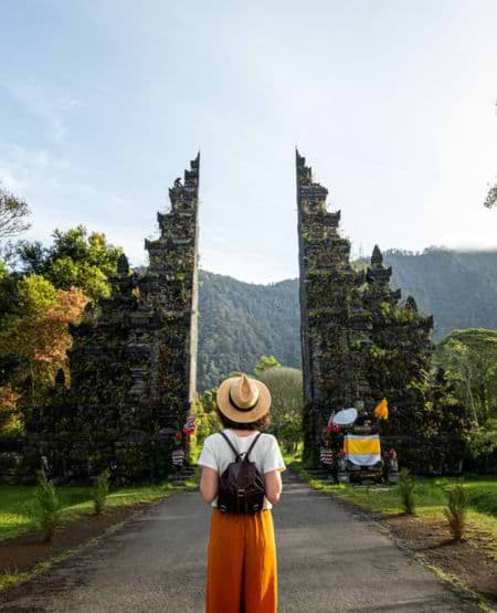 Kvinde ved port til hinduistisk tempel på Bali