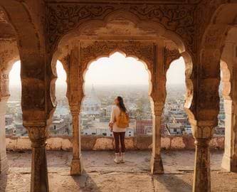Kvinde nyder udsigten ud over Jaipurs tage, Indien