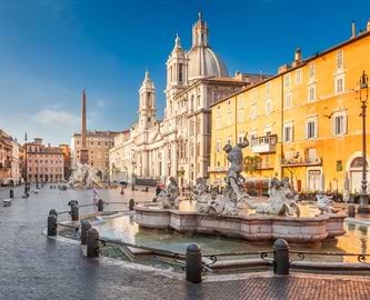 Piazza Navona i Rom med barokke springvand, den imponerende kirke Sant’Agnese in Agone og farverige bygninger i solskin. Piazza Navona i Rom med barokke springvand, den imponerende kirke Sant’Agnese in Agone og farverige bygninger i solskin.