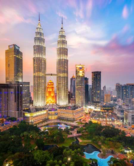 Udsigt over skyline i Kuala Lumpur med de ikoniske Petronas Towers og smukt aftenlys, Malaysia
