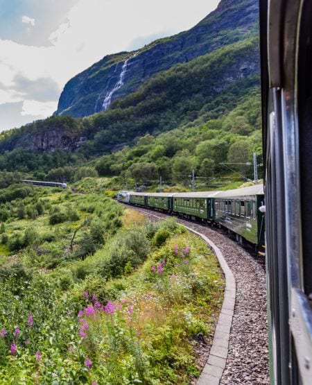 Flåmsbanen i Norge med udsigt til fjelde og vandfald Flåmsbanen i Norge med udsigt til fjelde og vandfald