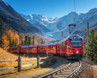 Togtur med Bernina Express i Schweiz med udsigt til sne og bjergtinder i Alperne Togtur med Bernina Express i Schweiz med udsigt til sne og bjergtinder i Alperne