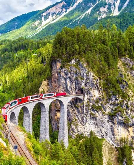 Bernina Express kører over den imponerende Landwasser viadukt i Schweiz Bernina Express kører over den imponerende Landwasser viadukt i Schweiz