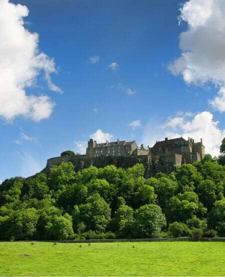 Stirling Castle troner majestætisk på en klippetop med udsigt over de omgivende grønne vidder, Skotland
