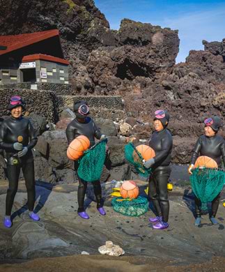 Kvindelige Haenyeo-fridykker med blæksprutte på Jeju Island, Sydkorea Kvindelige Haenyeo-fridykker med blæksprutte på Jeju Island, Sydkorea