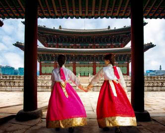 To sydkoreanske kvinder i traditionel klædedragt foran Gyeongbokgung-paladset i Seoul, Sydkorea To sydkoreanske kvinder i traditionel klædedragt foran Gyeongbokgung-paladset i Seoul, Sydkorea
