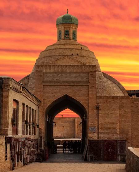 Handelscenter for pengeveksling Toqi Sarrofon i Bukhara, Usbekistan med solrød himmel i baggrunden