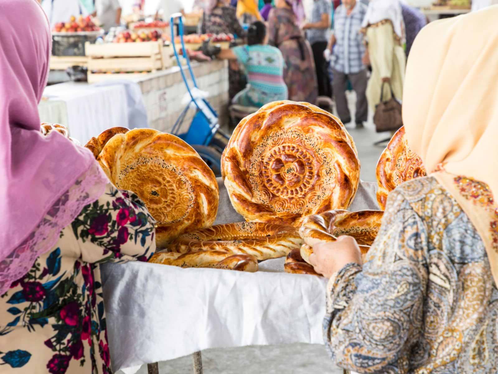 Lokale kvinder på marked med brød i Usbekistan
