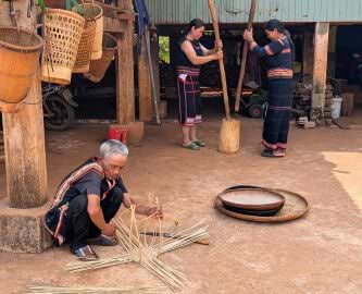 Vietnamesisk landsby, hvor mand i forgrund producerer kurveflet, Vietnam