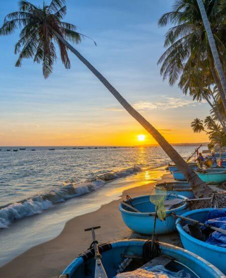Fiskere i små runde træbåde på stranden i Phan Thiet, Vietnam