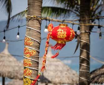 Stemningsbillede fra stranden i Da Nang med lanterner i palmerne Stemningsbillede fra stranden i Da Nang med lanterner i palmerne