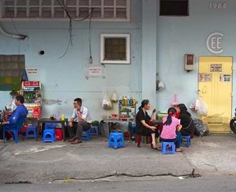 Vietnamesere sidder på små skamler i en gade i Ho Chi Minh City, Vietnam