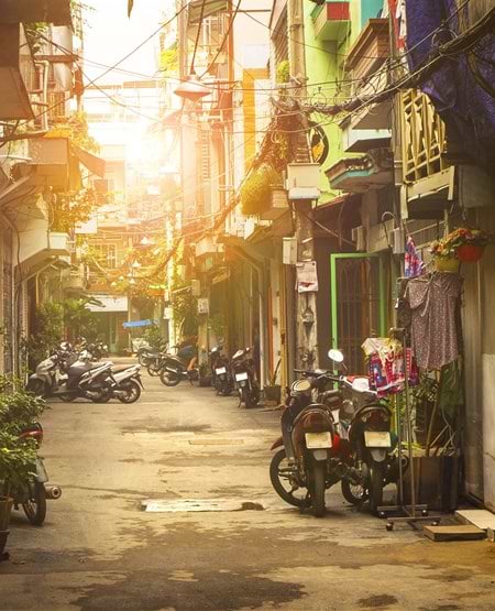 Scootere er parkeret i en smal, charmerende gade i Ho Chi Minh City, Vietnam