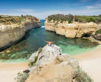 Turist nyder udsigt fra klippe over Loch Ard Gorge langs Australiens Great Ocean Road