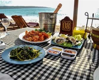 Dækket bord med skalddyr på stranden I Jimbaran på Bali