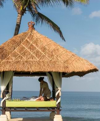 Kvinde som får massage på stranden på Bali