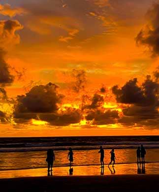 Silouetter af mennesker på stranden i solnedgang på Bali