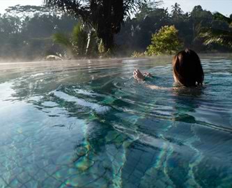 Kvinde der slapper af i poolen ved Sidemen på Bali Kvinde der slapper af i poolen ved Sidemen på Bali