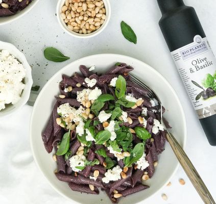 Biologische paarse wortel penne met kaas, basilicum en pijnboompitten