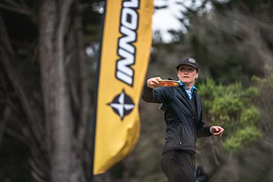 Holly Finley throwing in cold weather disc golf gear.