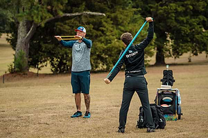 Disc golfers stretching before PDGA tournament round.
