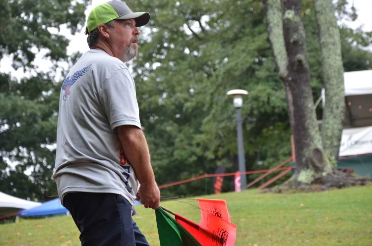 Newton readies himself to wave the green or red flag while spotting on Hole 18 on Friday