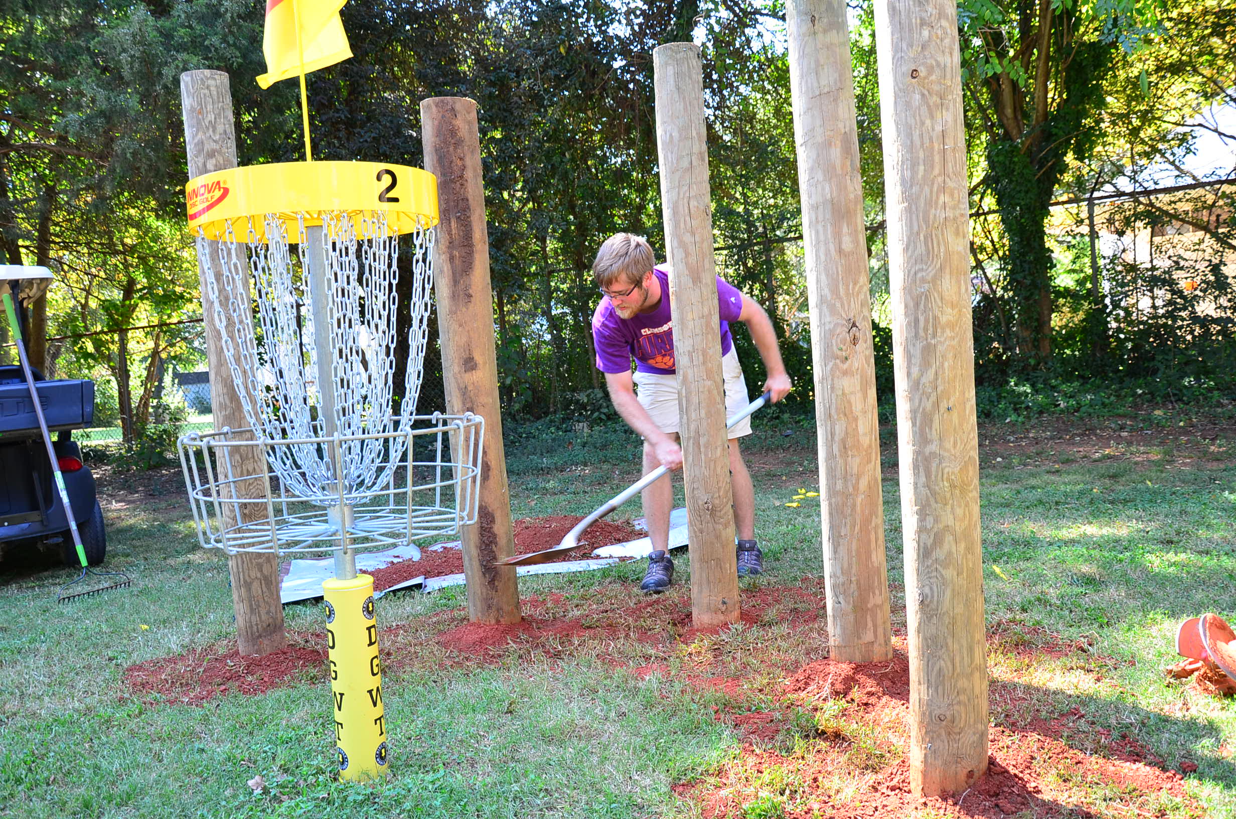 USDGC Staffer smoothes out the dirt surounding the newly planted pillars