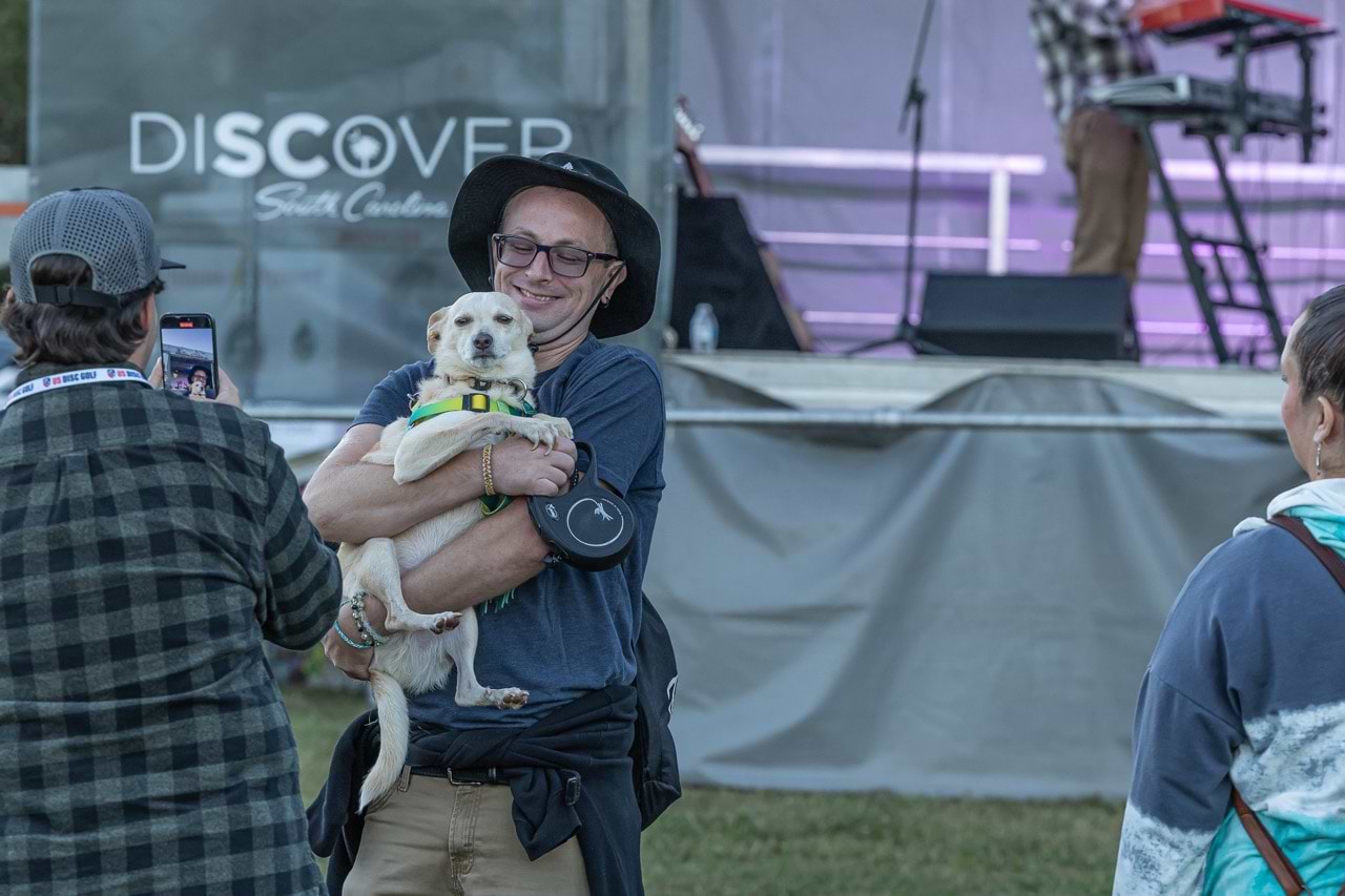 A fan enjoying the concert with his dog