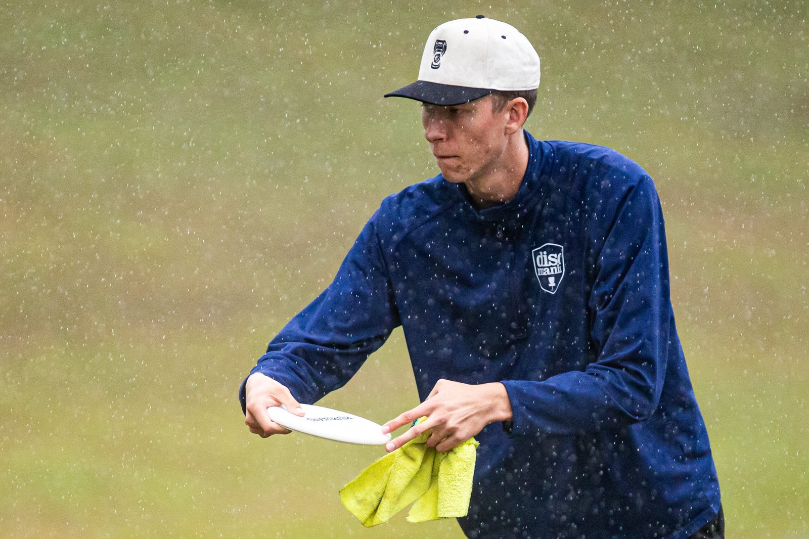 Gannon Buhr holds a white disc and a towel in the rain during Saturday’s third round at Winthrop.