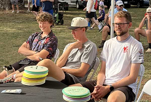 Competitors seated beside stacks of discs at the 2026 US Disc Golf Distance Championship.