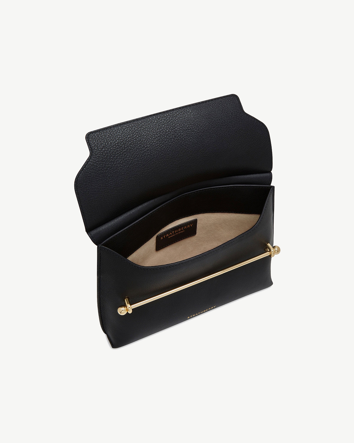 Black Stylist bag open showing beige interior, gold bar detail, Strathberry label.