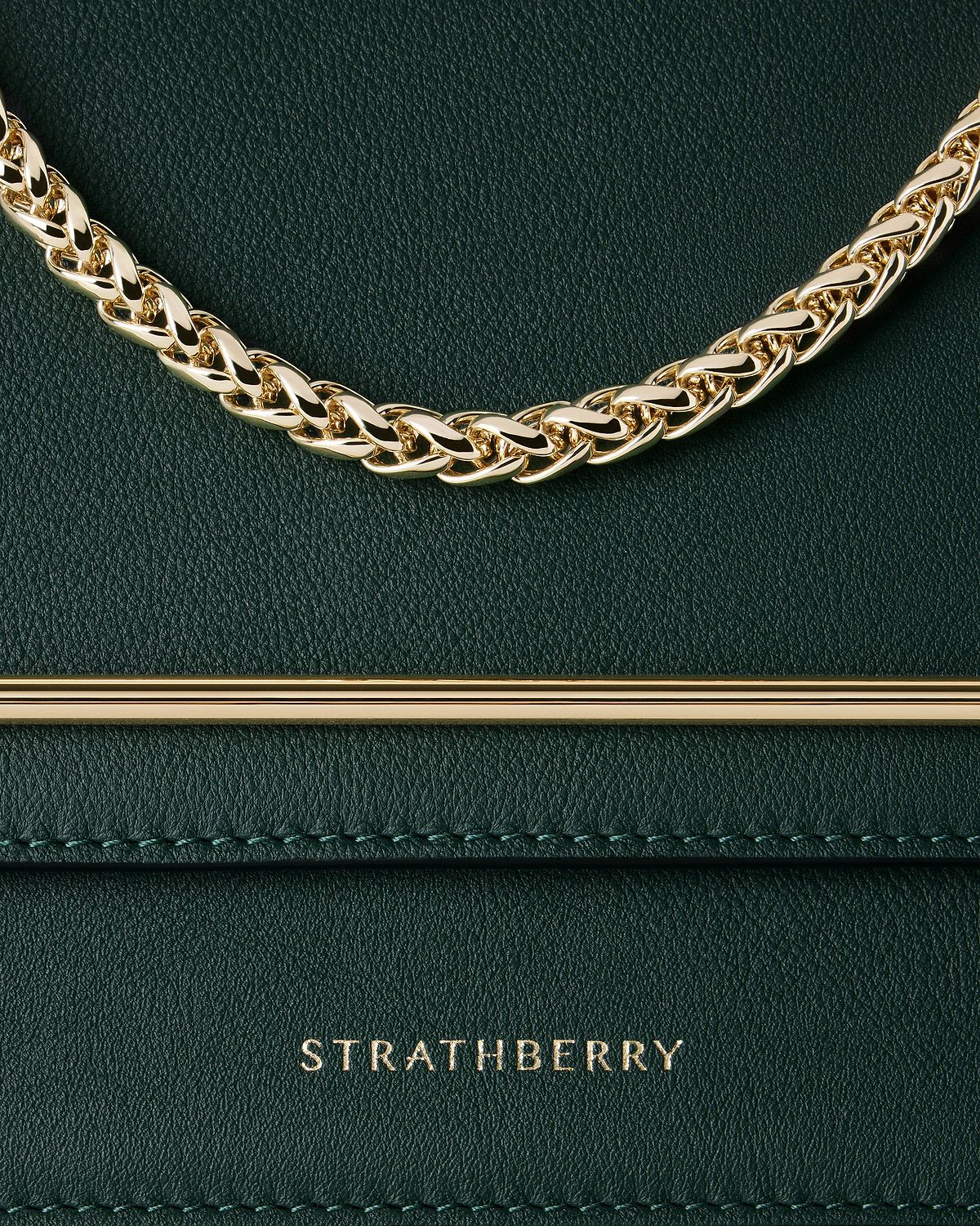 Bottle green leather bag detail with gold chain and Strathberry logo.