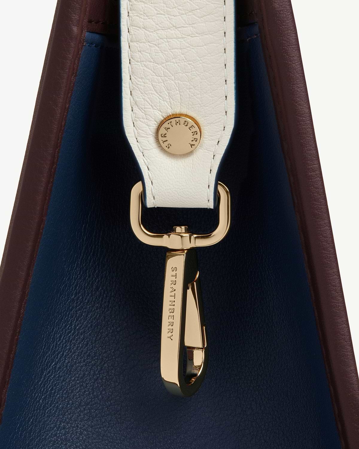 Burgundy and navy midi tote side with vanilla strap and gold Strathberry hardware