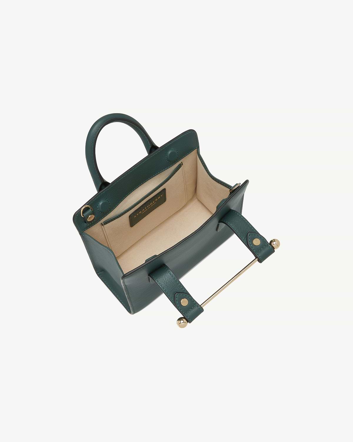 Bottle green Strathberry Nano tote open, showing beige interior and gold bar closure.