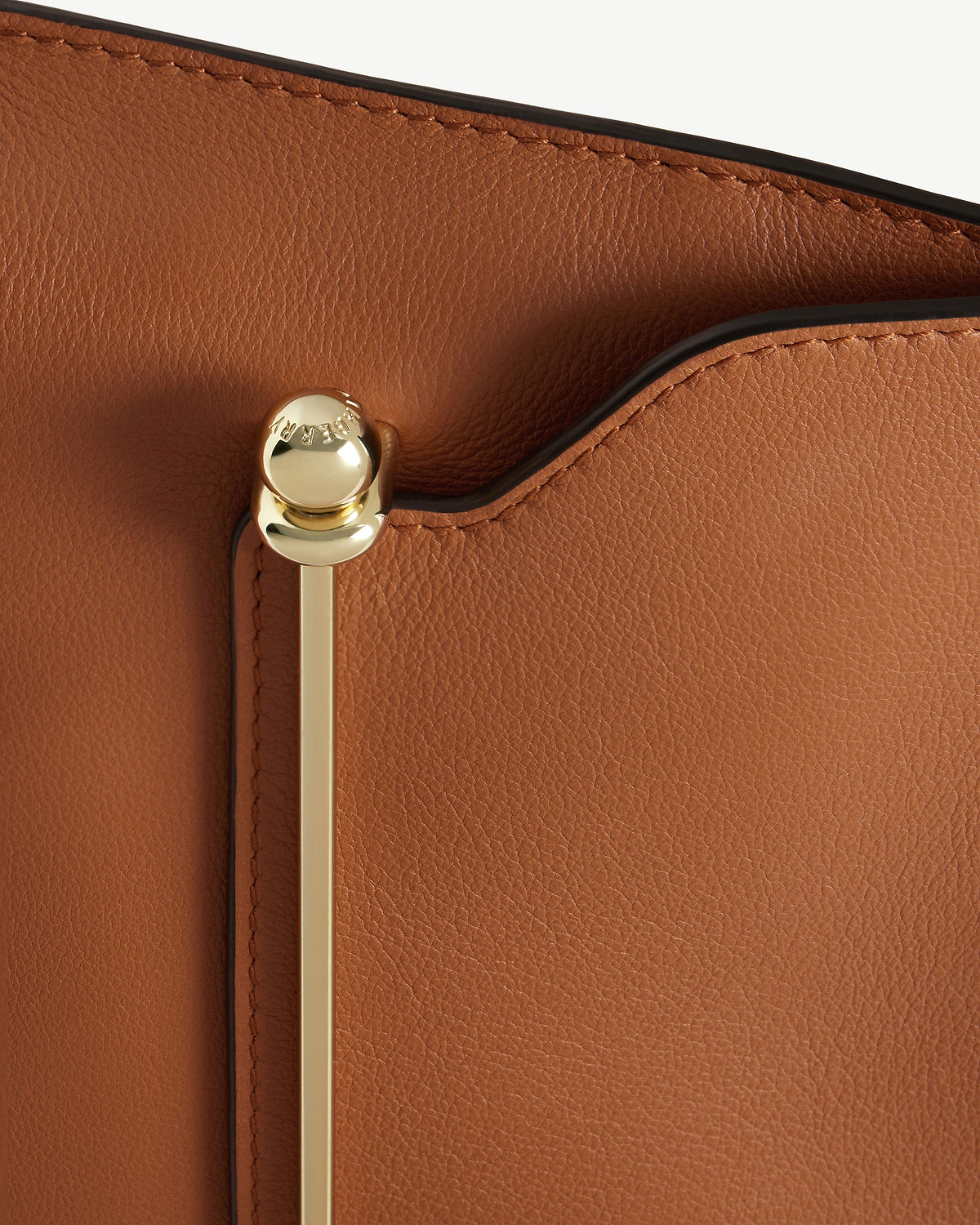Chestnut pebbled leather Stylist bag with gold bar hardware and black piping.