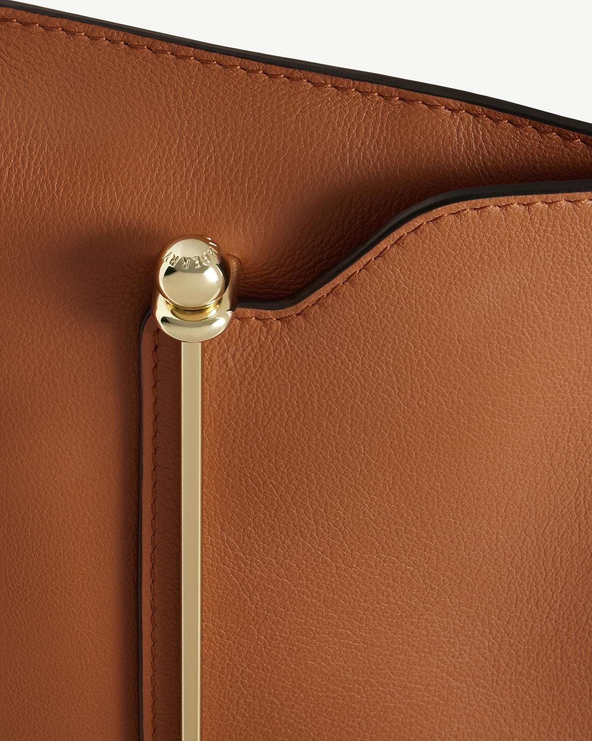 Chestnut pebbled leather Stylist bag with gold bar hardware and black piping.